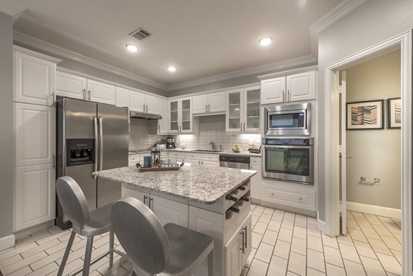 Spacious kitchen featuring marble countertops and stainless steel appliances in Manchester State Thomas Apartments