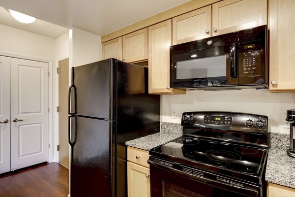 Modern kitchen with stainless steel appliances and island at 70 Capitol Yards Apartments in vibrant city setting