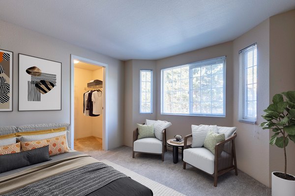 Contemporary bedroom with plush bedding and large window at Bay Court at Harbour Pointe Apartments, offering stylish comforts in a serene community