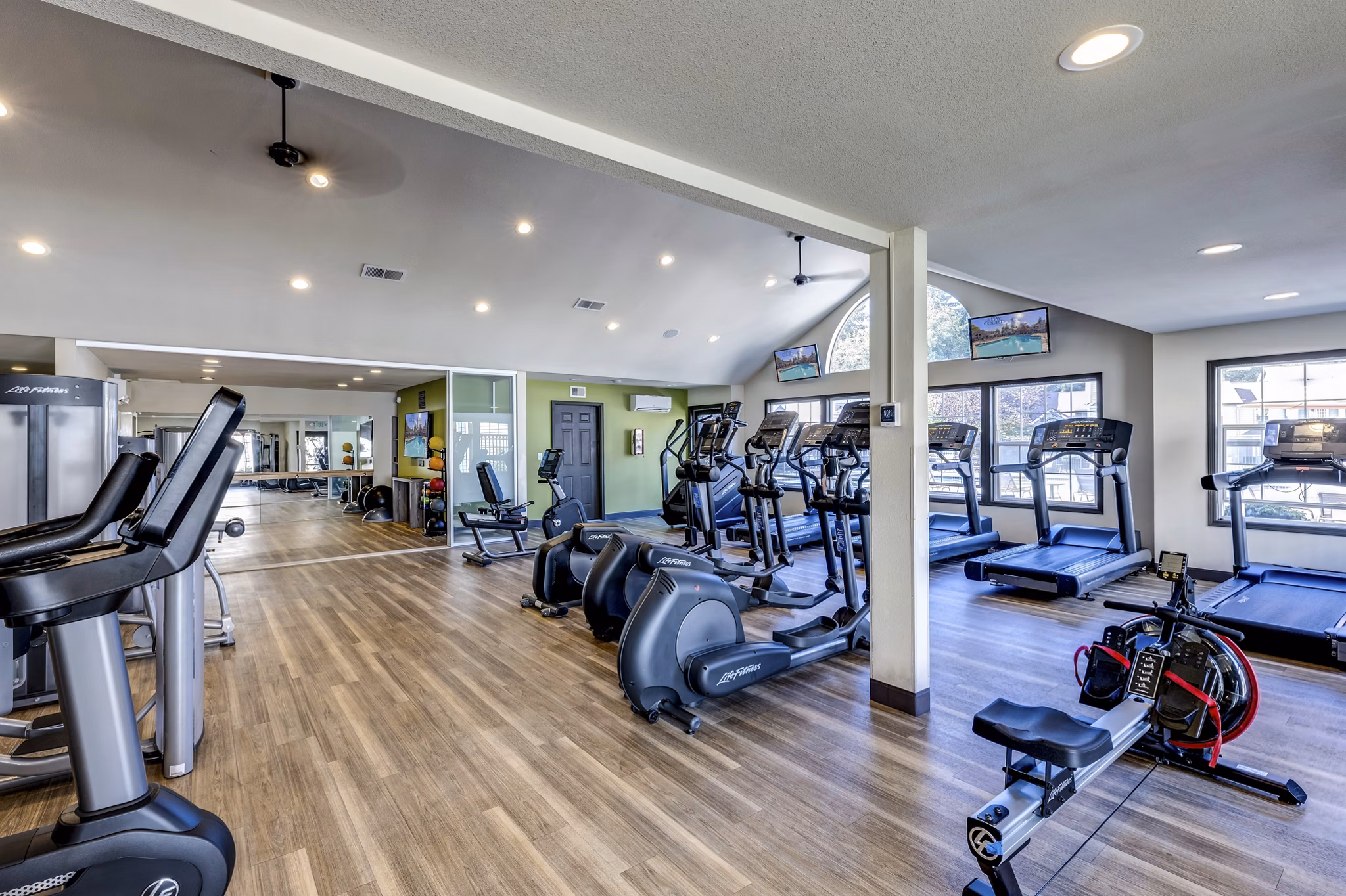 Modern fitness center with cardio machines at Bay Court at Harbour Pointe Apartments