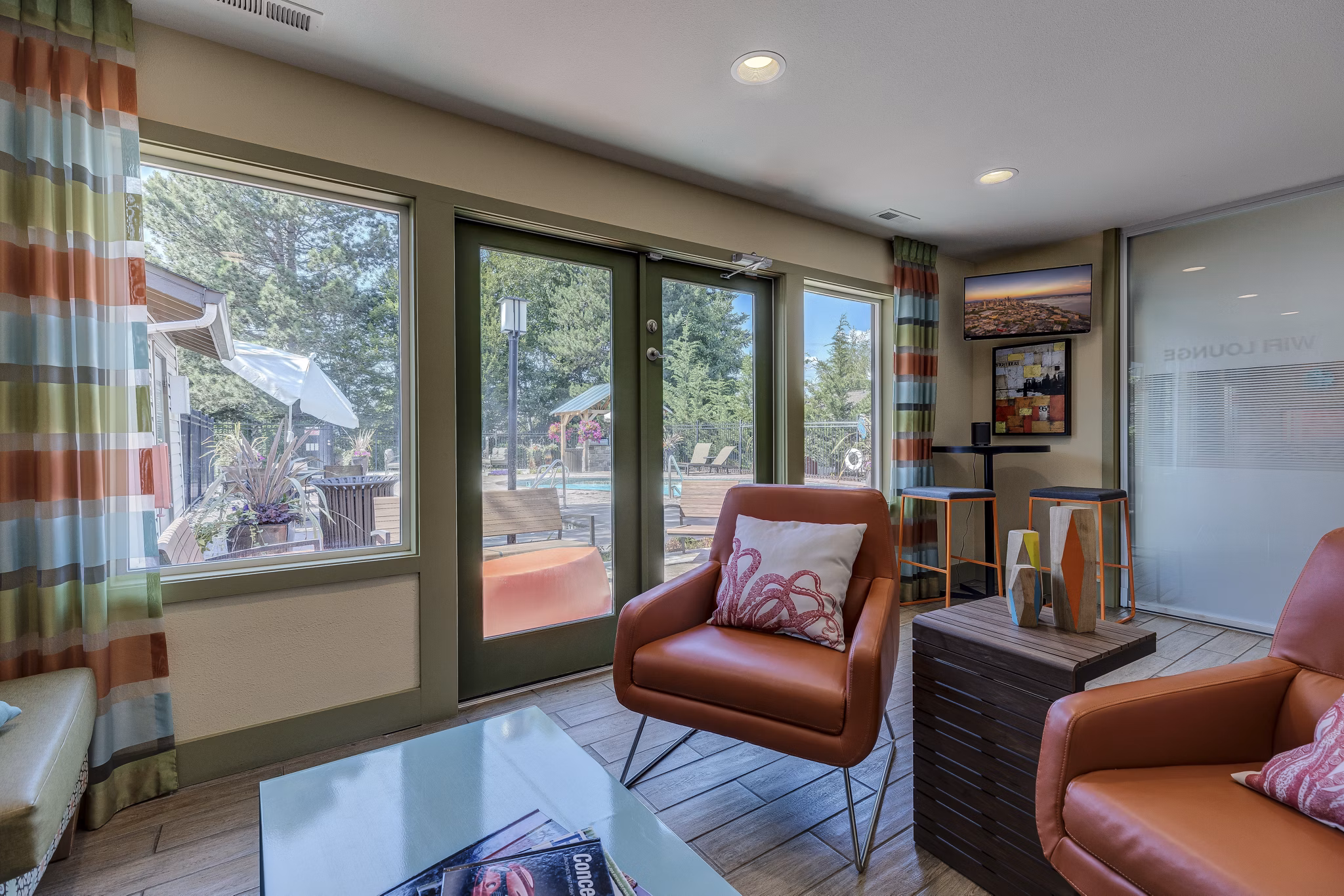 Clubhouse at The Berkshire Apartments featuring a modern lounge area with stylish seating and games for resident enjoyment