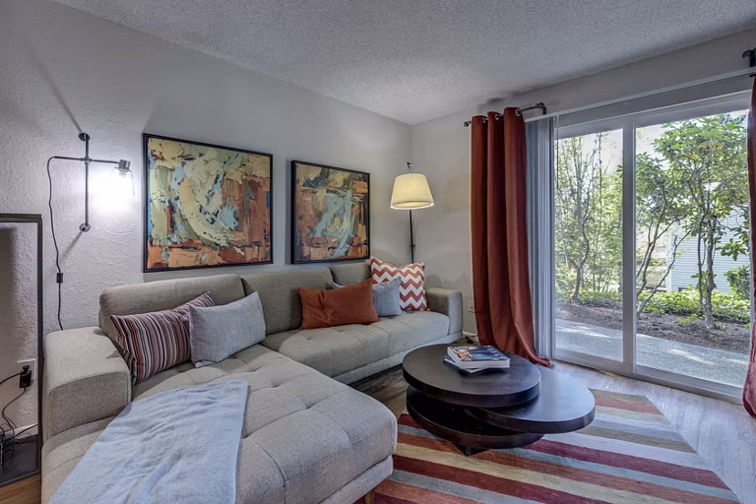 Spacious living room with stylish decor in The Berkshire Apartments, featuring modern furniture and elegant lighting