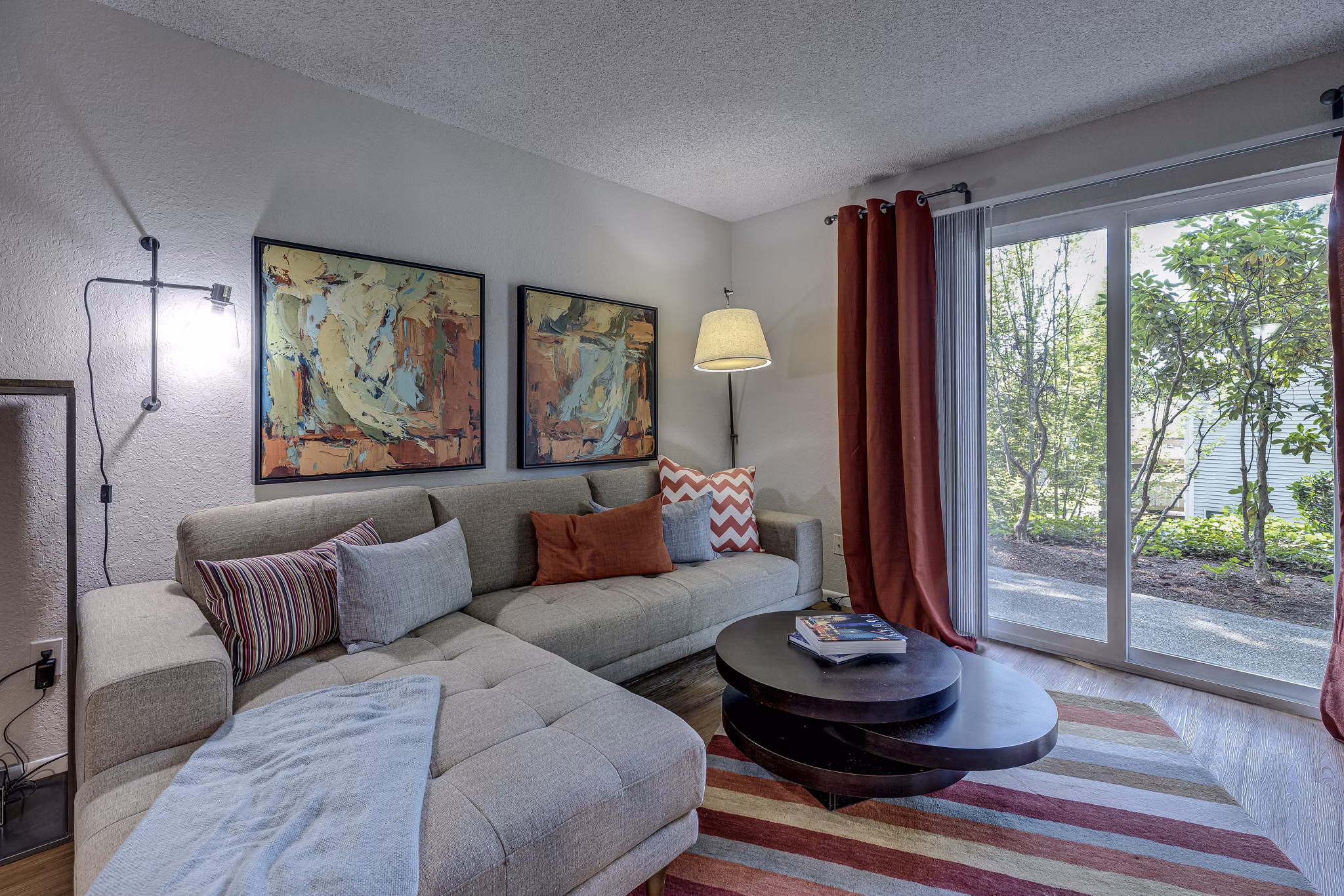Spacious living room with stylish decor in The Berkshire Apartments, featuring modern furniture and elegant lighting
