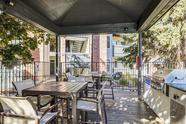 Modern grill area at Stratford Station Apartments with outdoor seating and lush landscaping, perfect for entertaining and relaxation