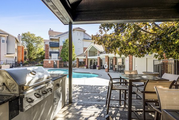Grill area with modern communal seating at Stratford Station Apartments, perfect for social gatherings and outdoor dining