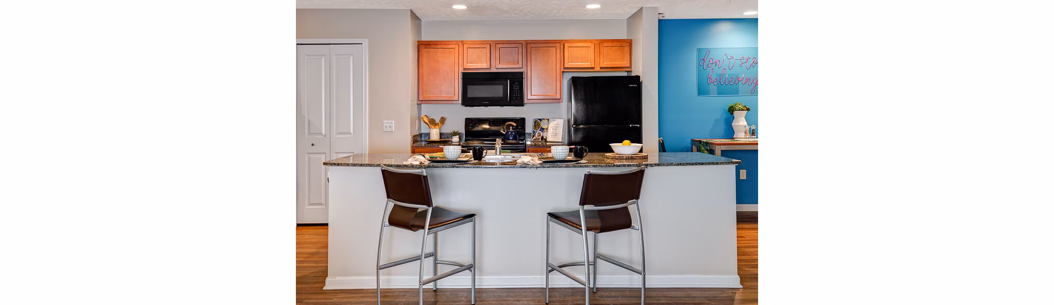 Kitchens featuring stainless steel appliances and granite countertops in Campus Pointe Apartments