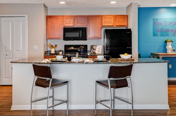 Kitchens featuring stainless steel appliances and granite countertops in Campus Pointe Apartments