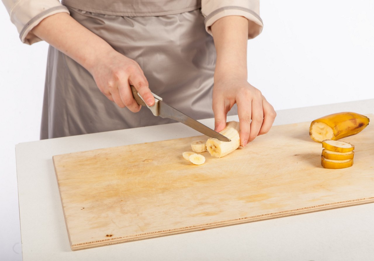 Chef cuts a banana with a knife