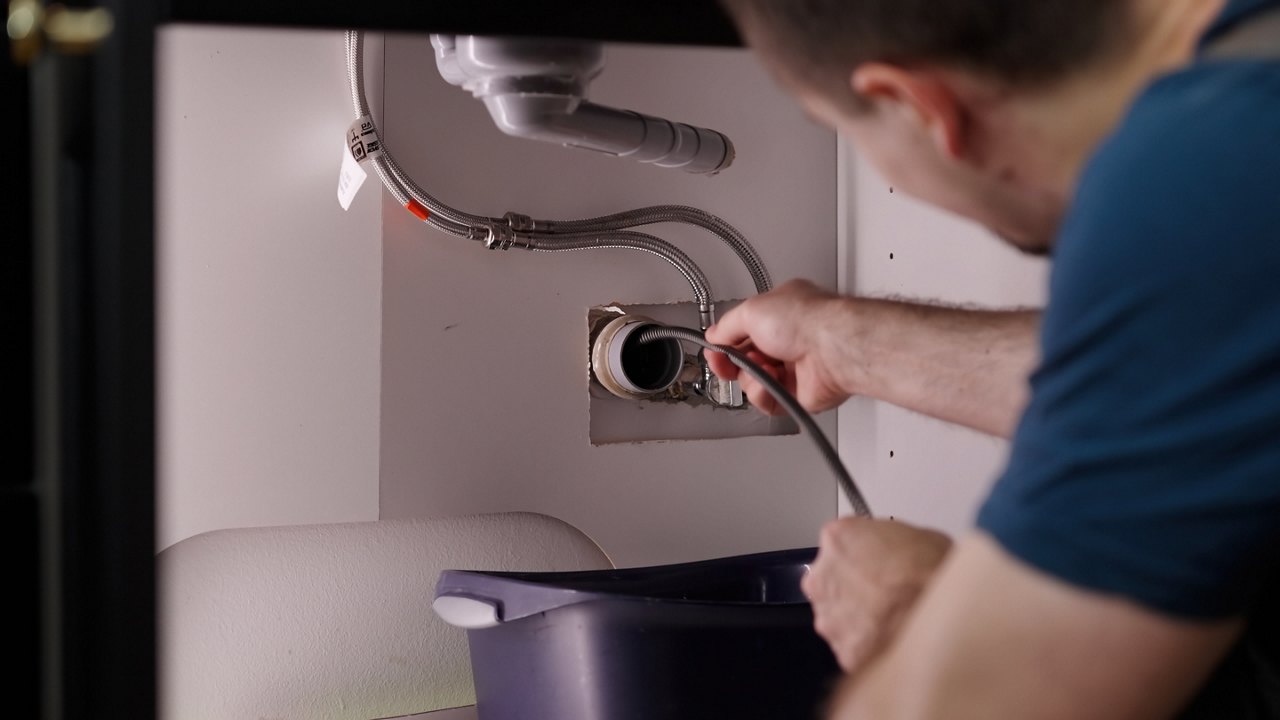 Plumber drill through clogged sink pipes with spring tube tool 