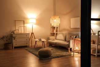 Interior of modern living room with grey sofa, coffee table and glowing lamps at evening