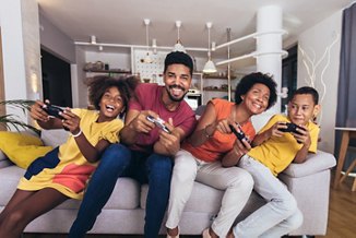 African American family playing video games together and having fun at home
