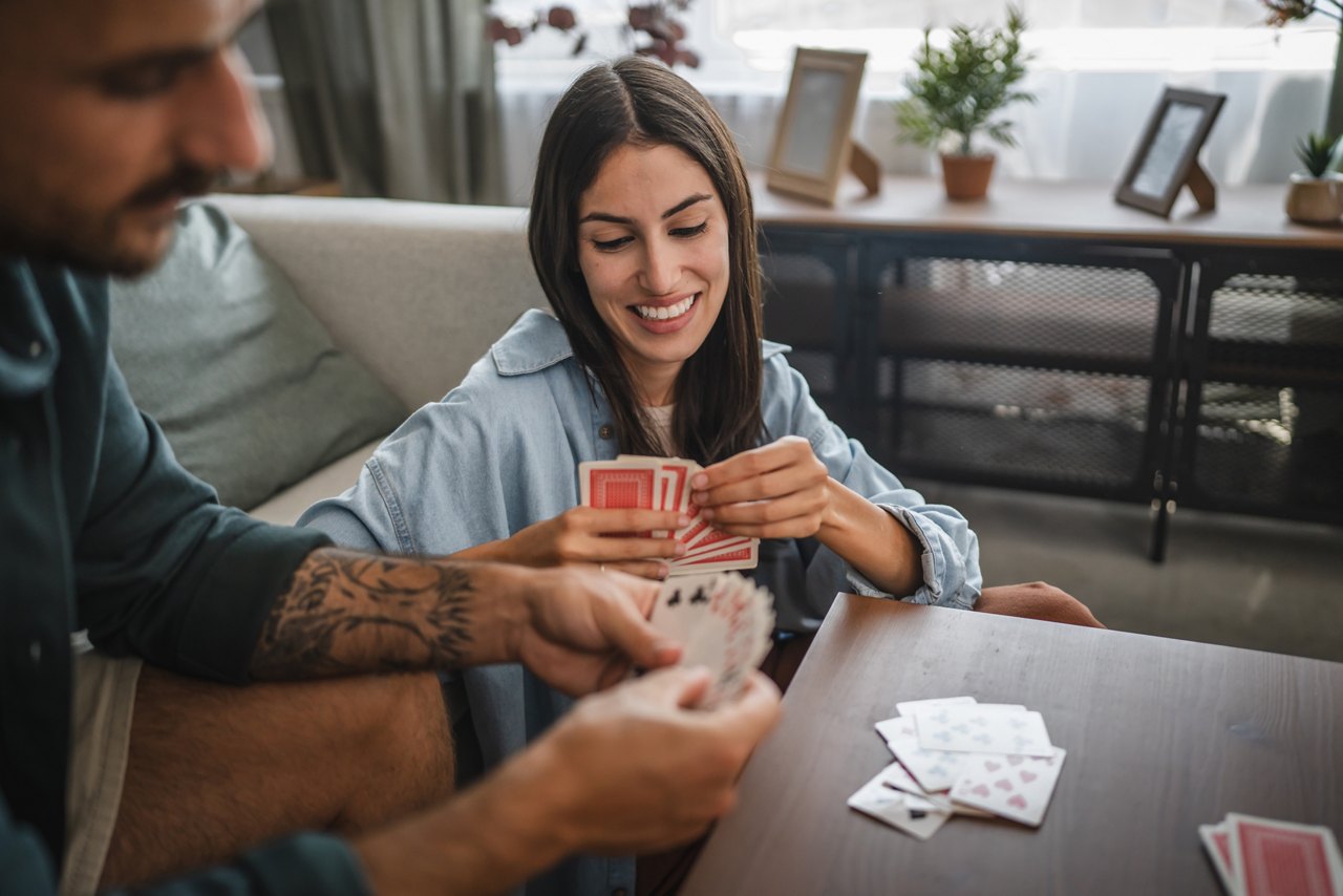 Girlfriend sit on the floor and hold card play with her boyfriend