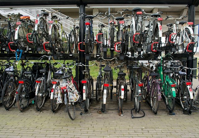 A double-decker bicycle parking rack filled with various bicycles.