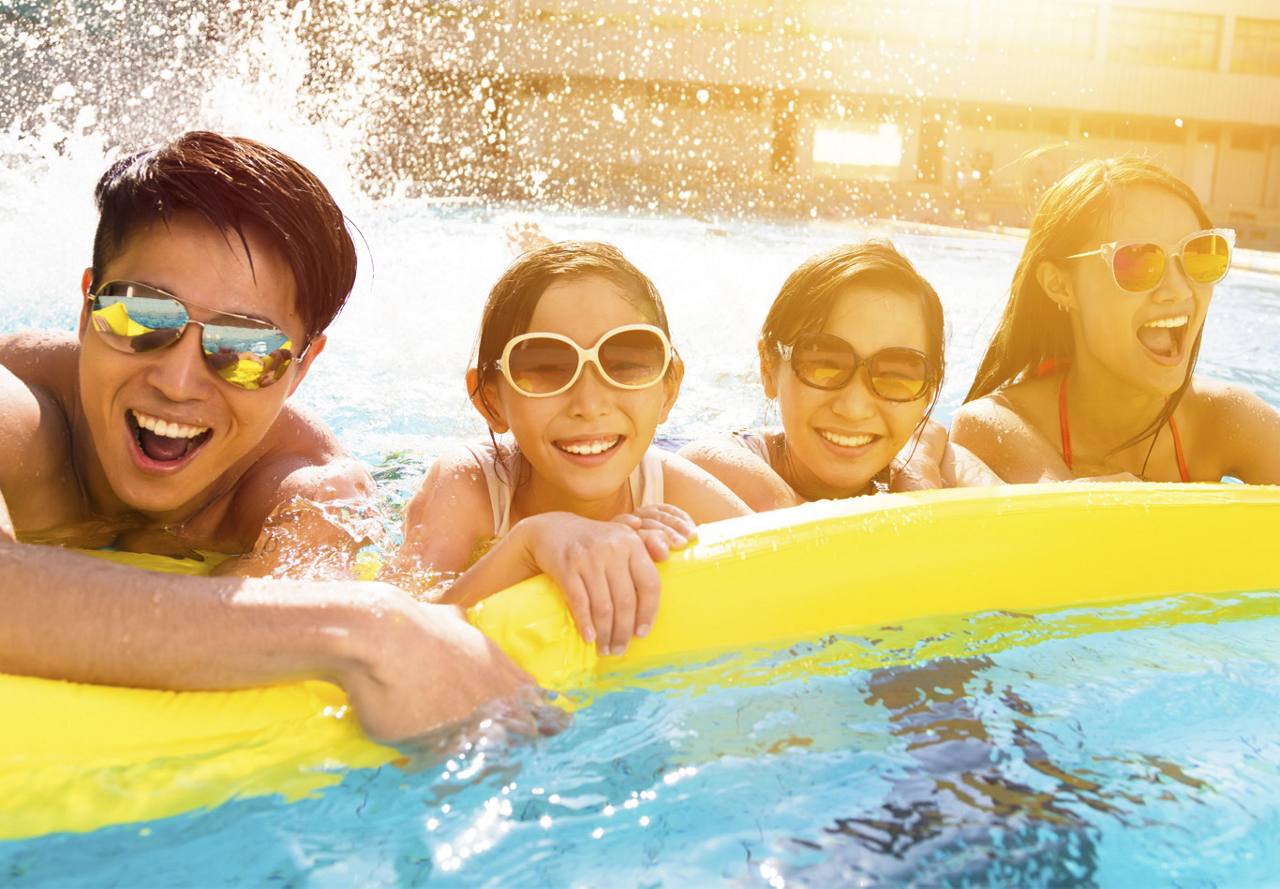 A group of people enjoying themselves in a pool.