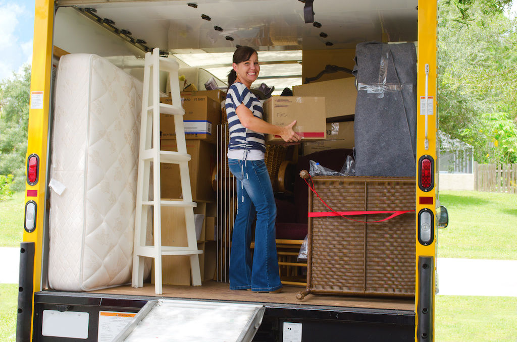 Woman loading moving van at apartment