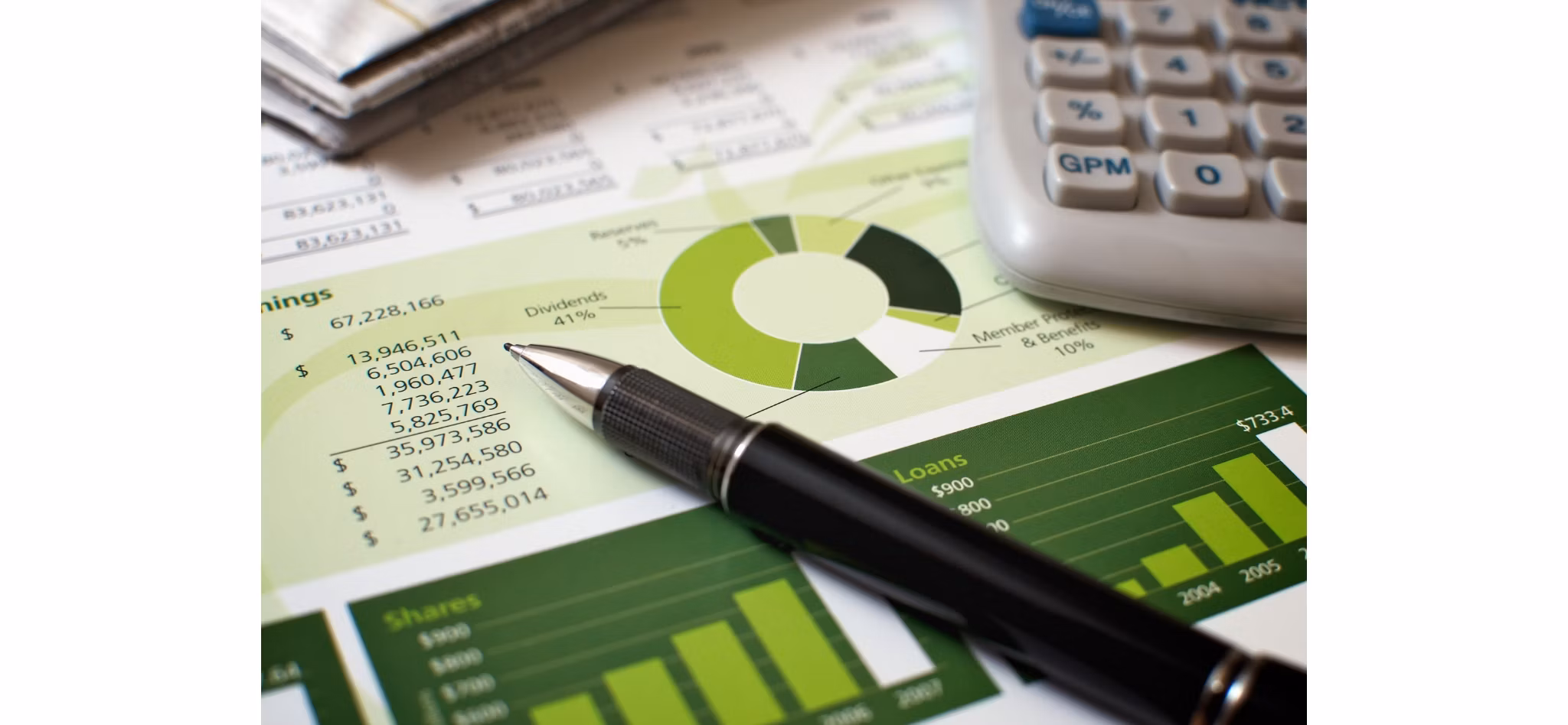 Financial charts and graphs with a pen and calculator indicating analysis for financial planning.