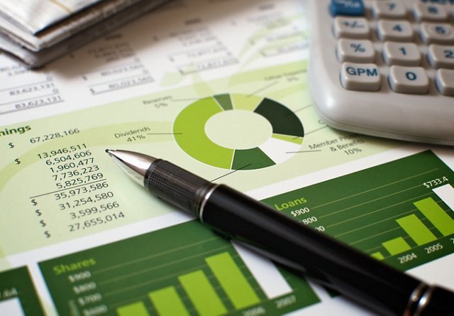 Financial charts and graphs with a pen and calculator indicating analysis for financial planning.