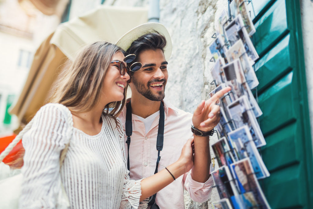 Young couple on vacation looking at postcards