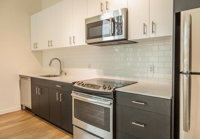 Modern kitchen with white cabinetry, stainless steel appliances, and subway tile backsplash.