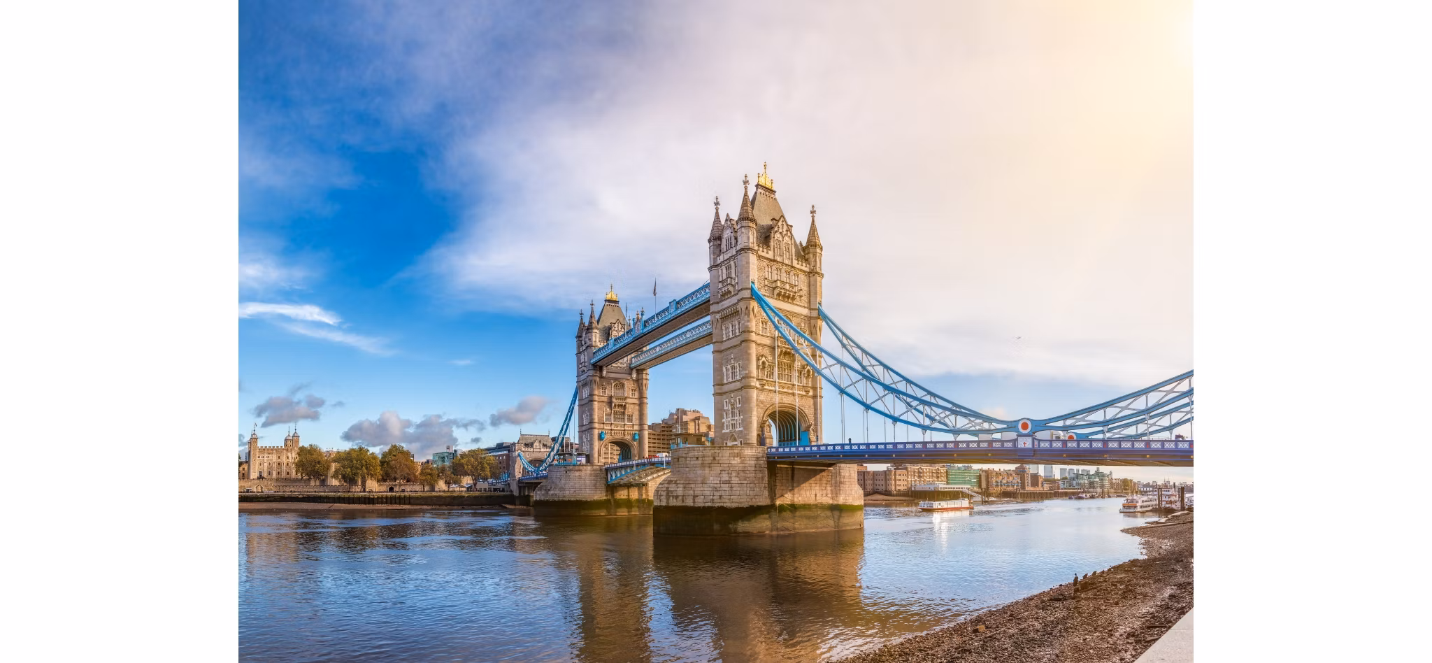 Panoramic view of Tower Bridge in London over the River Thames on a sunny day with blue skies.
