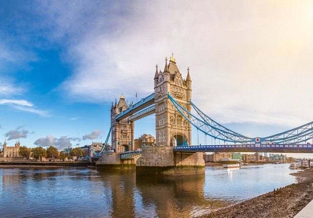 Panoramic view of Tower Bridge in London over the River Thames on a sunny day with blue skies.