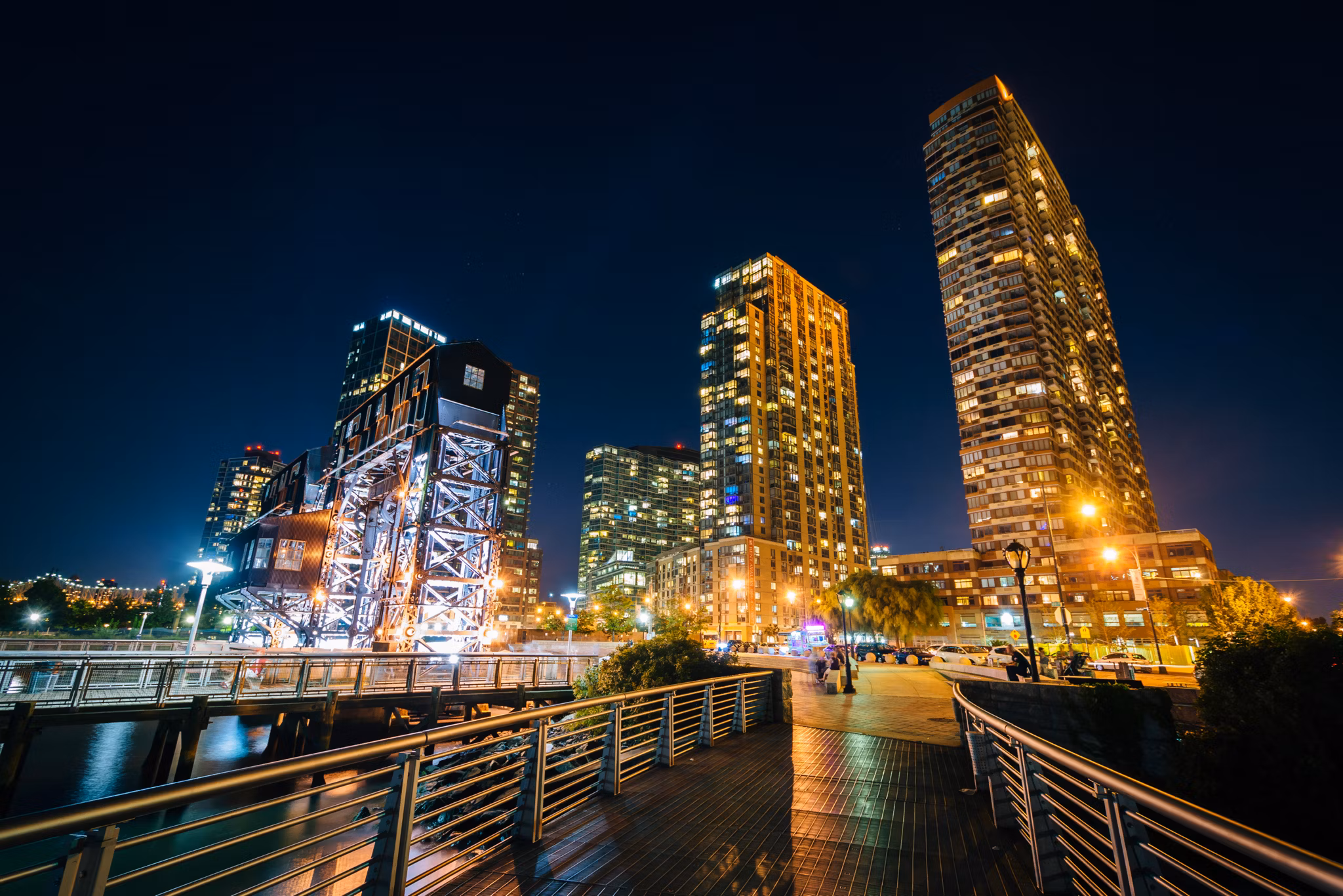Walkway and Long Island City at night, seen from Gantry Plaza State Park, Queens, New York.