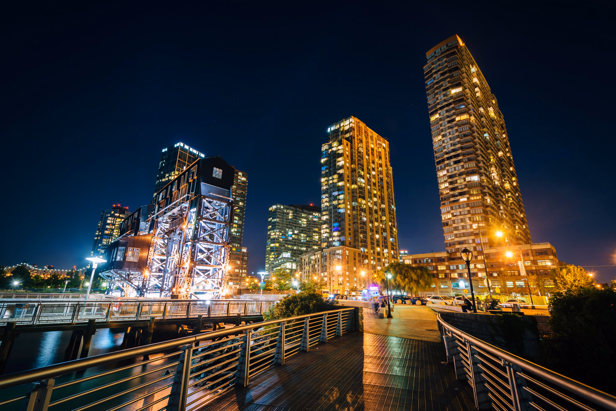 Walkway and Long Island City at night, seen from Gantry Plaza State Park, Queens, New York.