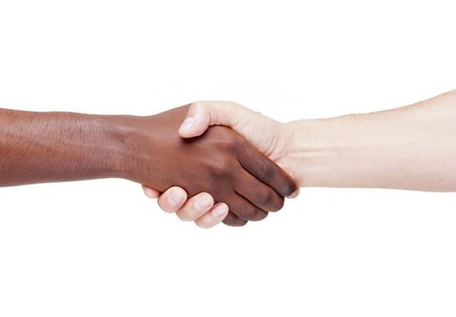 Handshake between two individuals of different ethnicities, symbolizing diversity and inclusion, isolated on a white background.