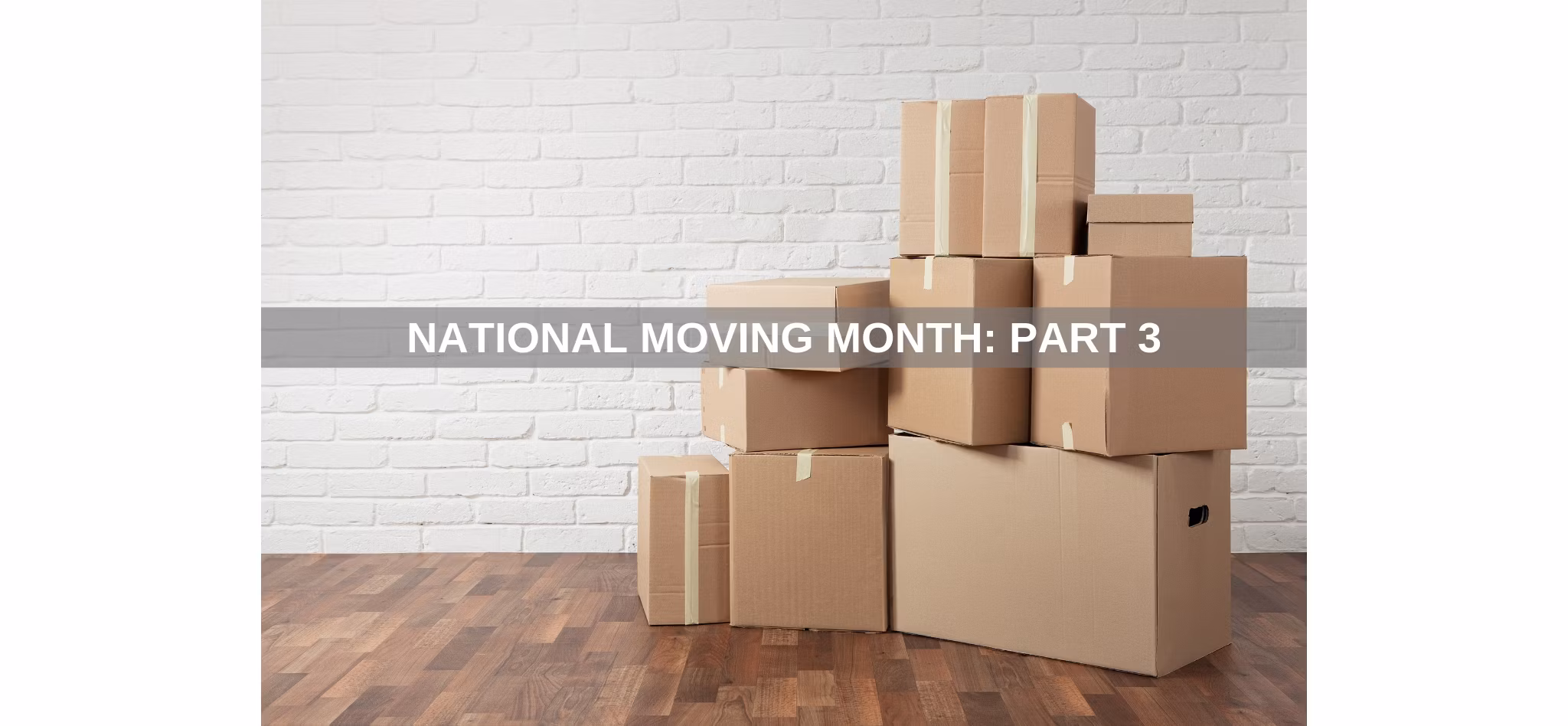 Piled cardboard boxes against a white brick wall on a wooden floor, with the text 'National Moving Month: Part 3'.