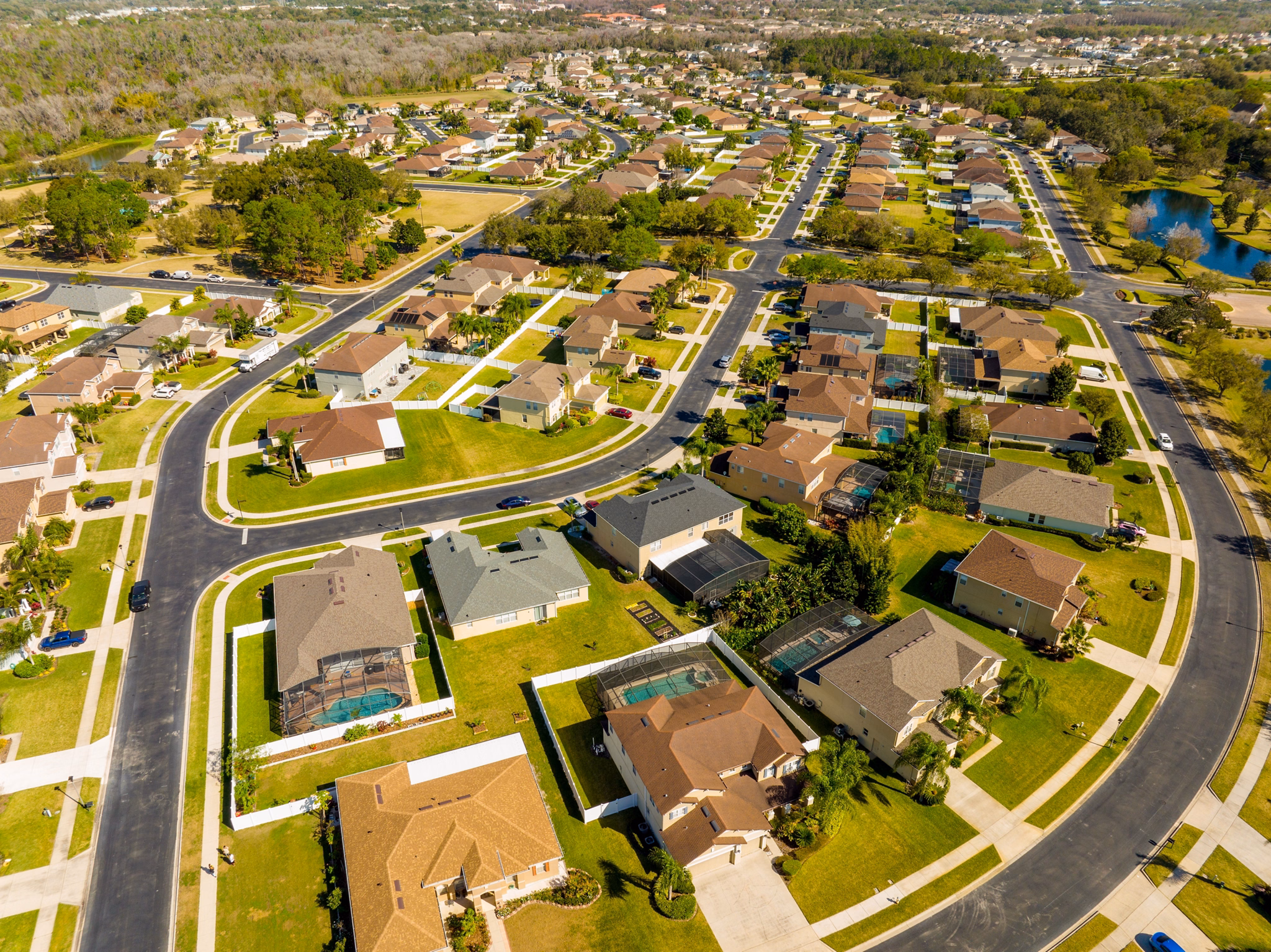  Aerial view of Horizon West, Florida, showing curved suburban streets lined with houses, many with pools and green lawns.