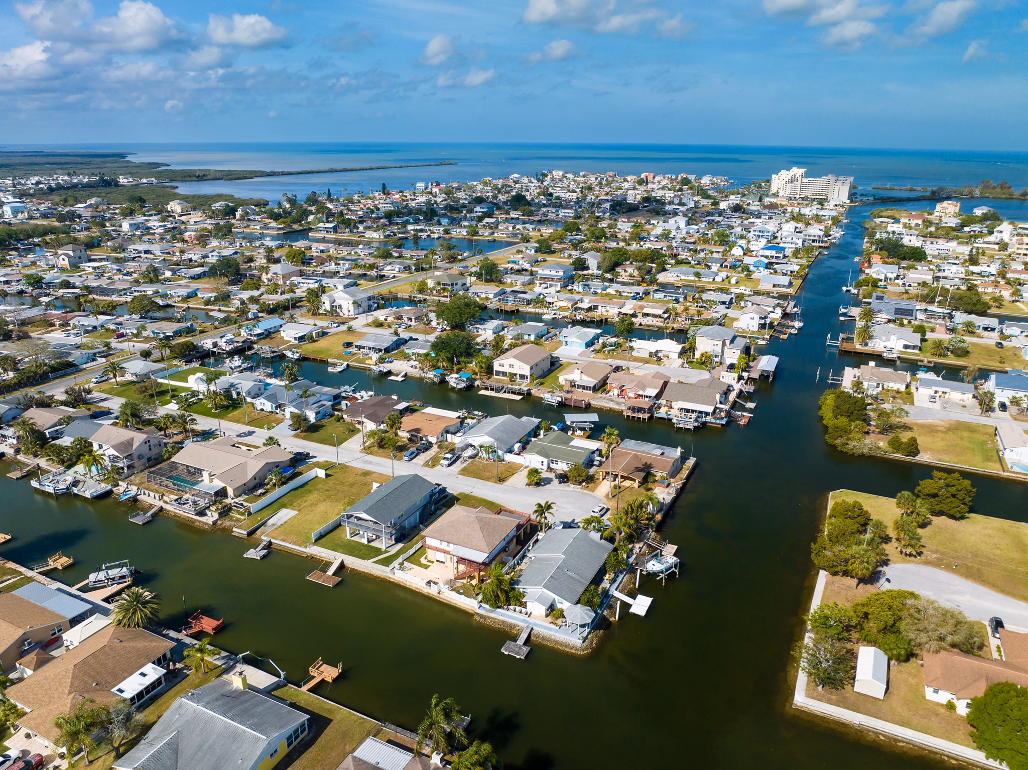 Aerial view of Pasco County, Florida, showing waterfront homes with boat docks along canals, leading to the Gulf of Mexico.
