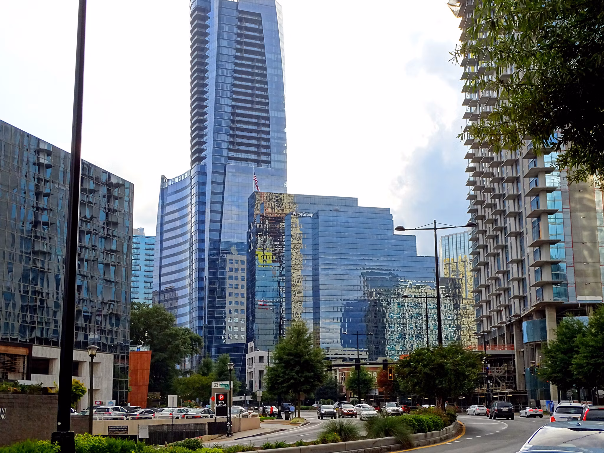 Modern glass skyscrapers and high-rise buildings in Sandy Springs/Roswell/North Fulton Area, GA with street traffic below.