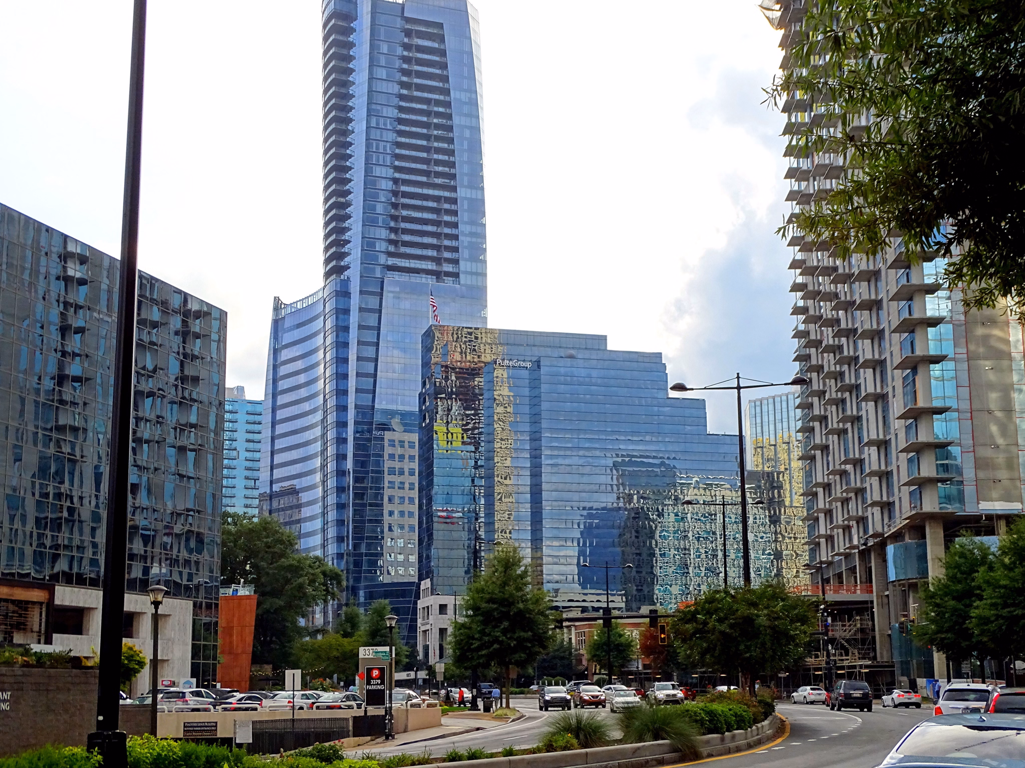 Modern glass skyscrapers and high-rise buildings in Sandy Springs/Roswell/North Fulton Area, GA with street traffic below.