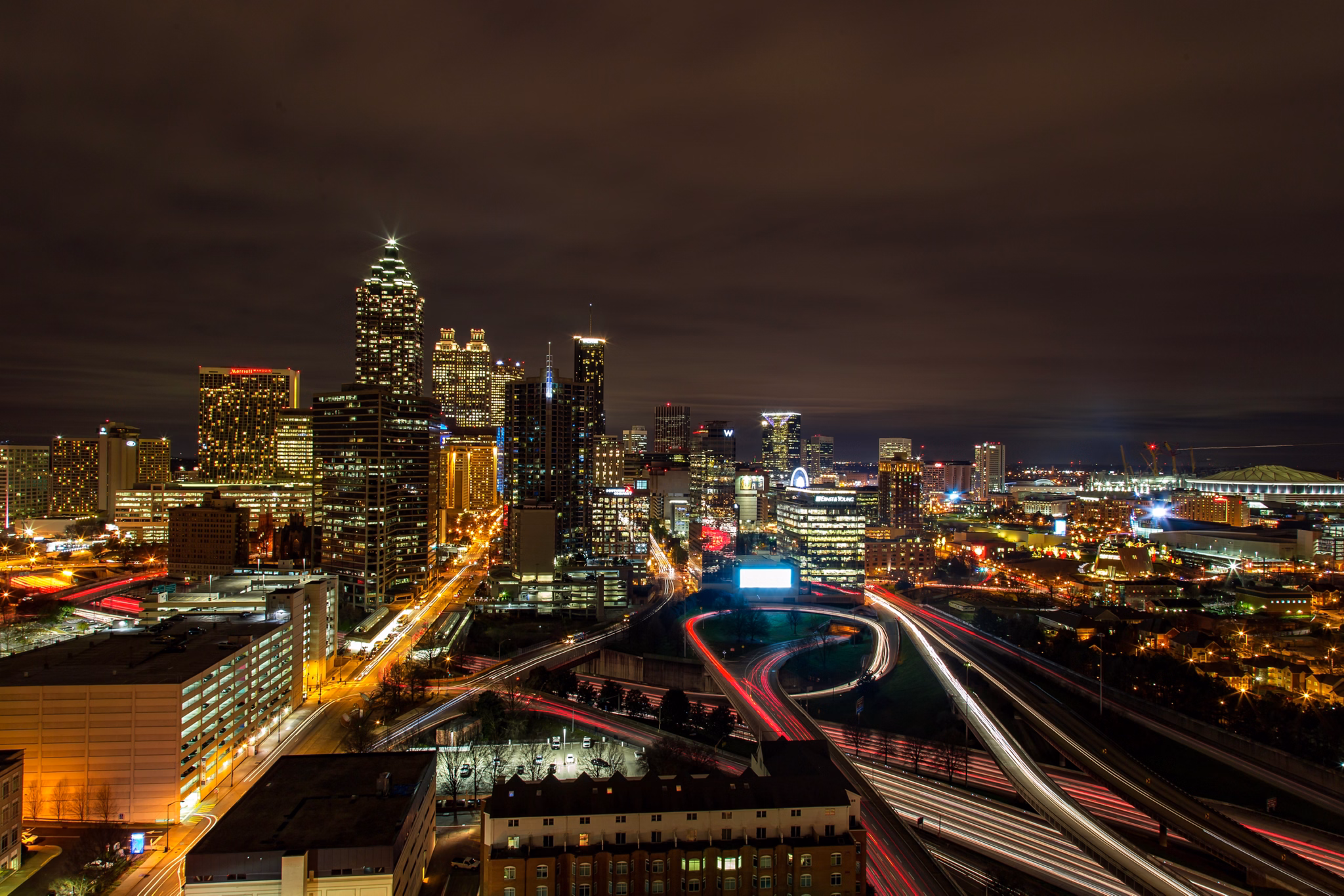 Night skyline view from Smyrna/Vinings, GA with illuminated Atlanta skyscrapers, highway lights, and sports venues.