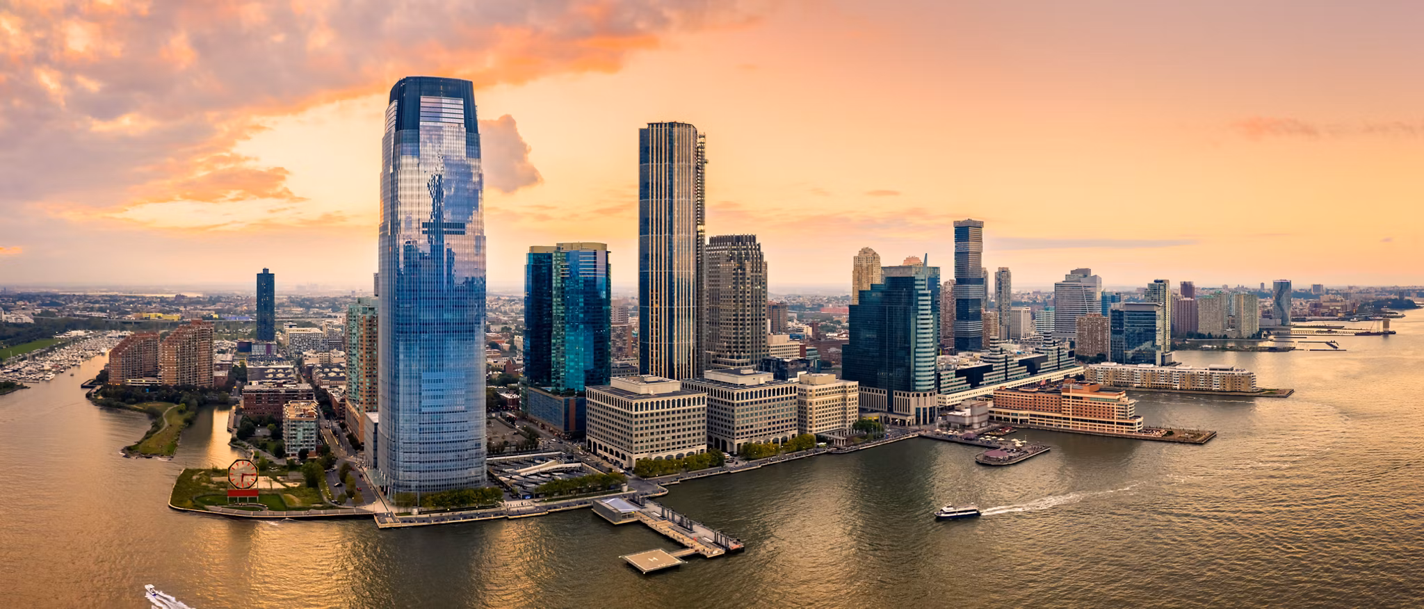 Aerial panorama of Jersey City skyline at sunset.