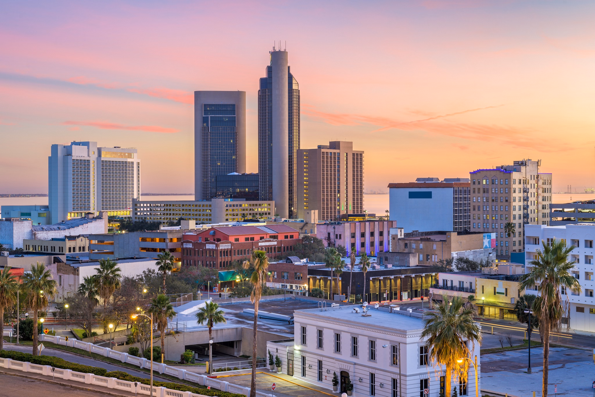 View of Southside/Bay Area in Texas at sunset, showcasing tall buildings and a colorful city skyline.