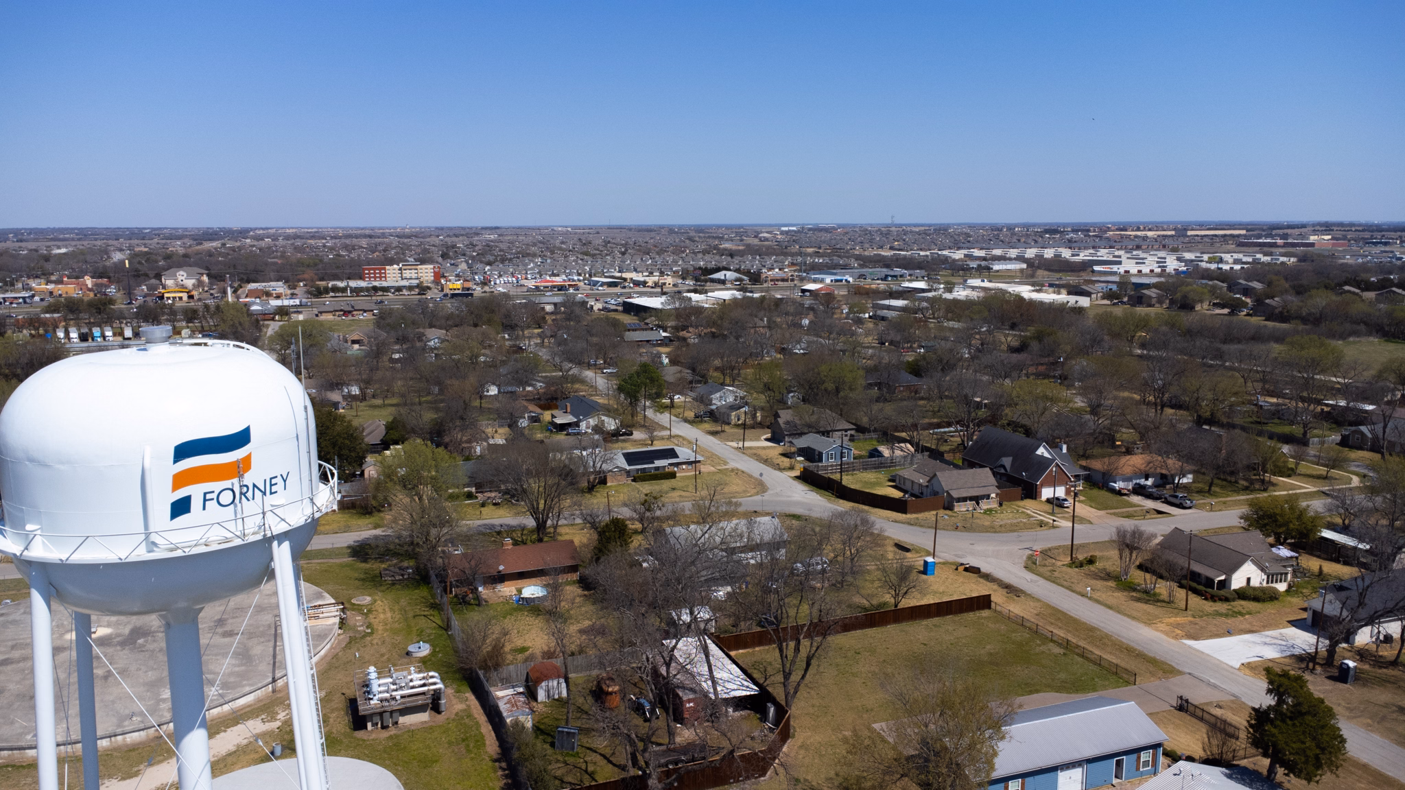 Aerial view of the Crandall/Forney neighborhood in Texas, showing houses, roads, and a prominent water tower.