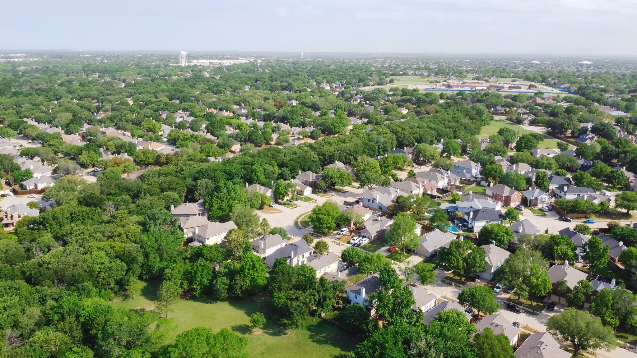 Aerial view of the Flower Mound neighborhood in Texas, featuring many houses surrounded by lush green trees.