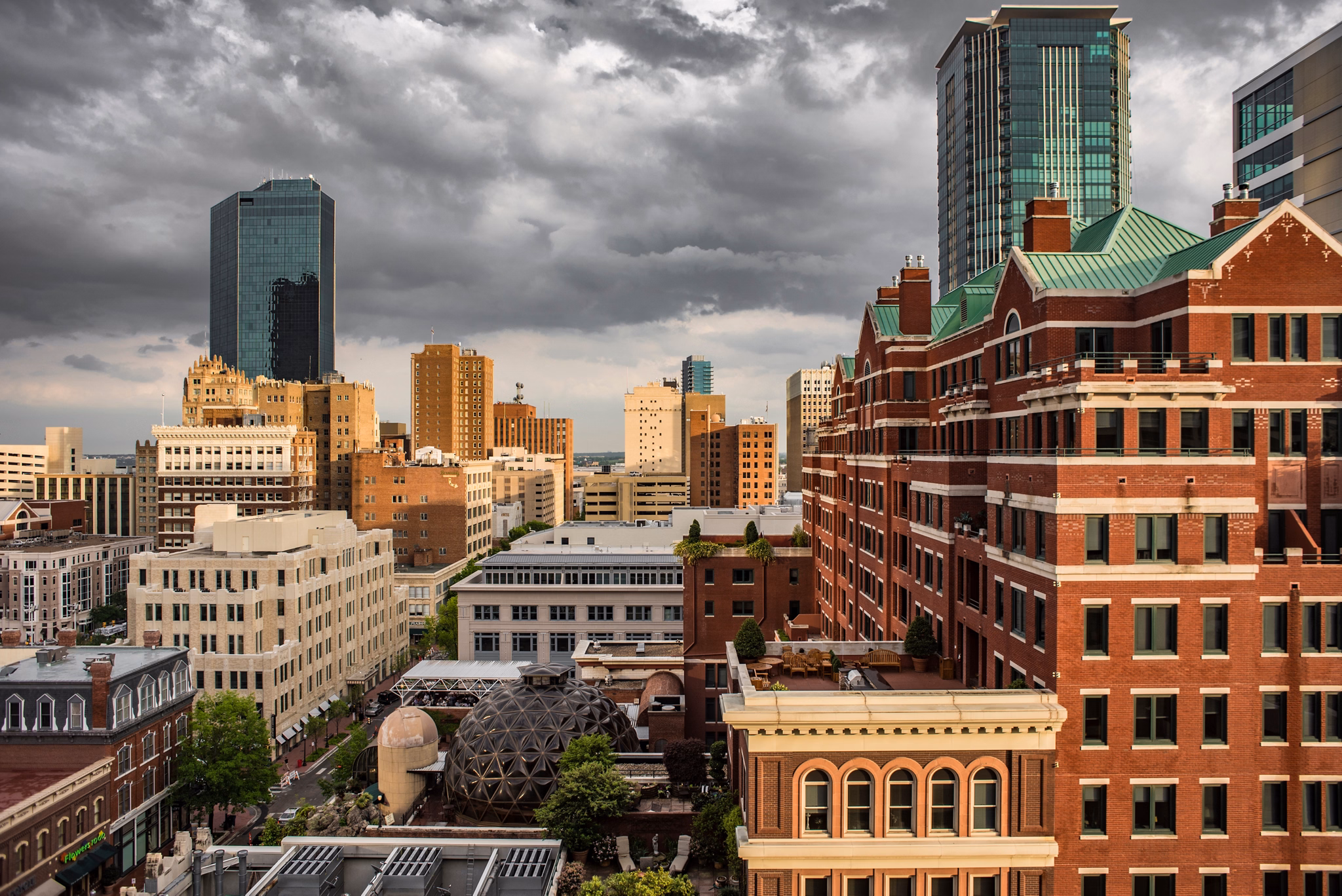 A skyline view of Sundance Square in the Upper West Side of Texas, featuring tall buildings and dark, cloudy skies.