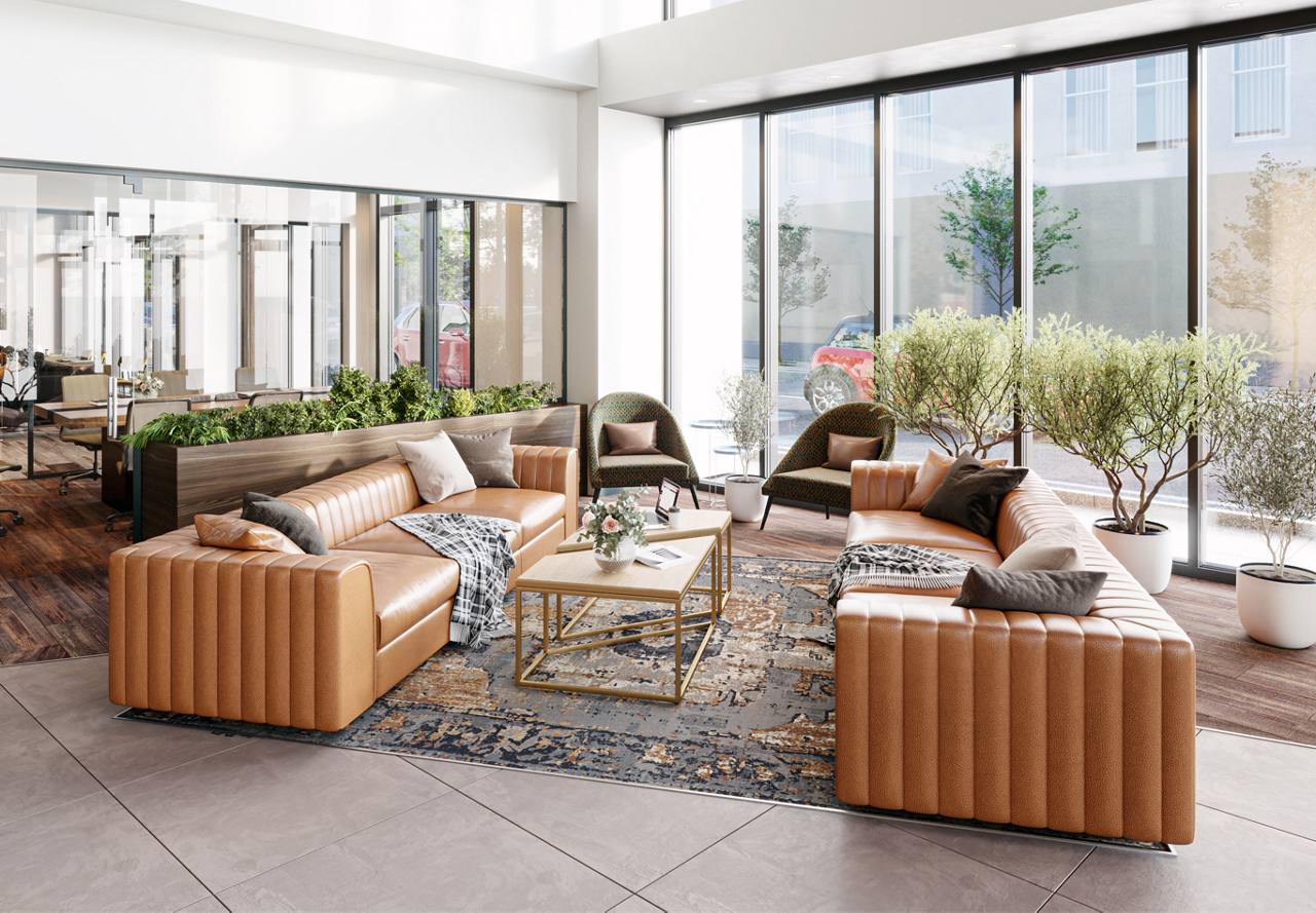 Chic lobby area with tan leather sofas, patterned armchairs, and potted trees near floor-to-ceiling windows.