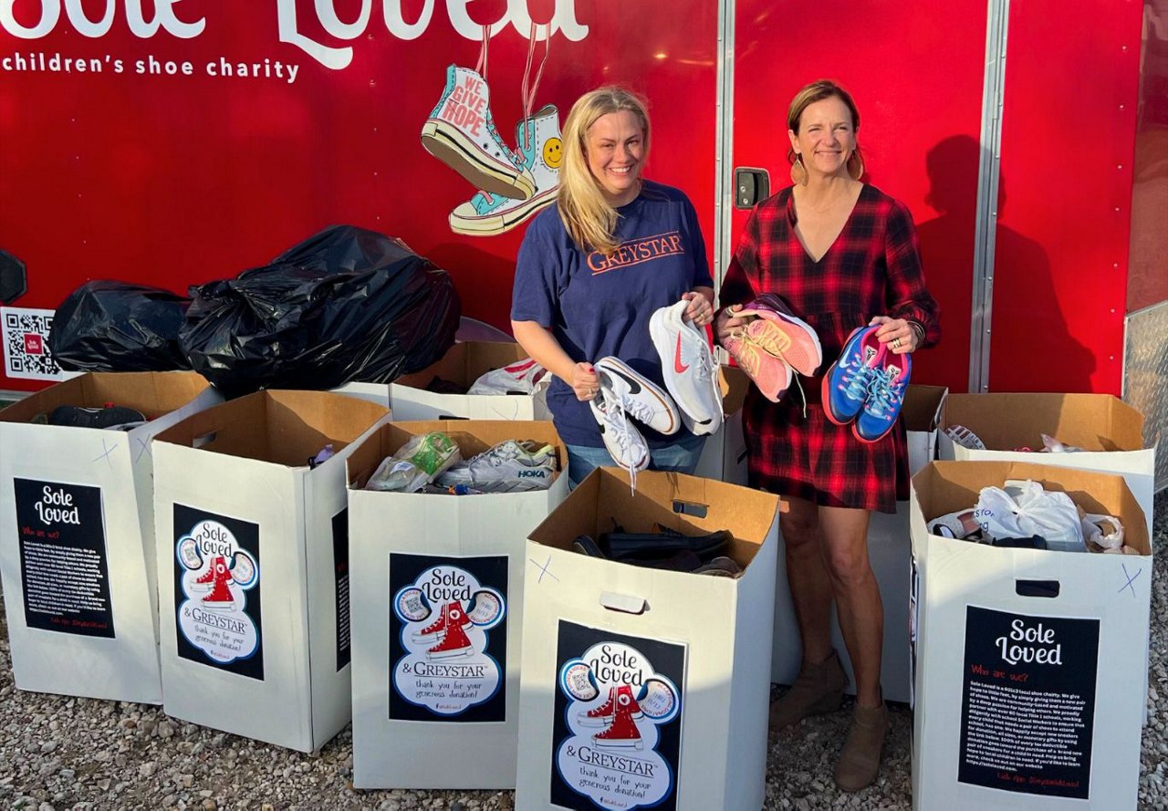 Two people donating shoes to the 'Sole Loved' children's shoe charity.