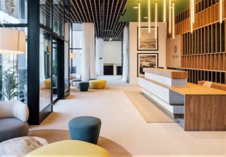 Modern lobby interior with stylish seating, wood accents, and warm lighting, creating a welcoming and contemporary space.