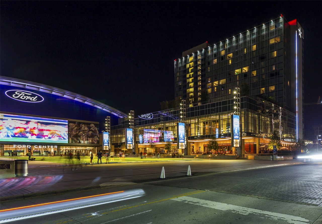 Nighttime view of Frisco, Texas, featuring the illuminated Ford Center and The Star, home to the Dallas Cowboys.