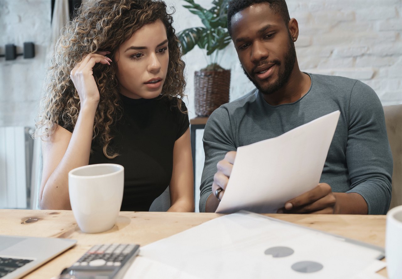 Couple looking at their finances and budget in their home while sitting at a table