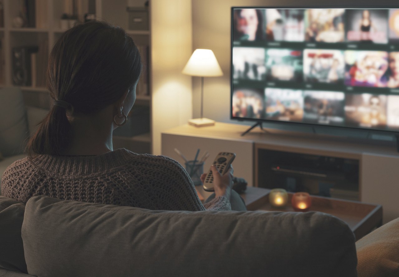 Woman sitting on the couch streaming on her television