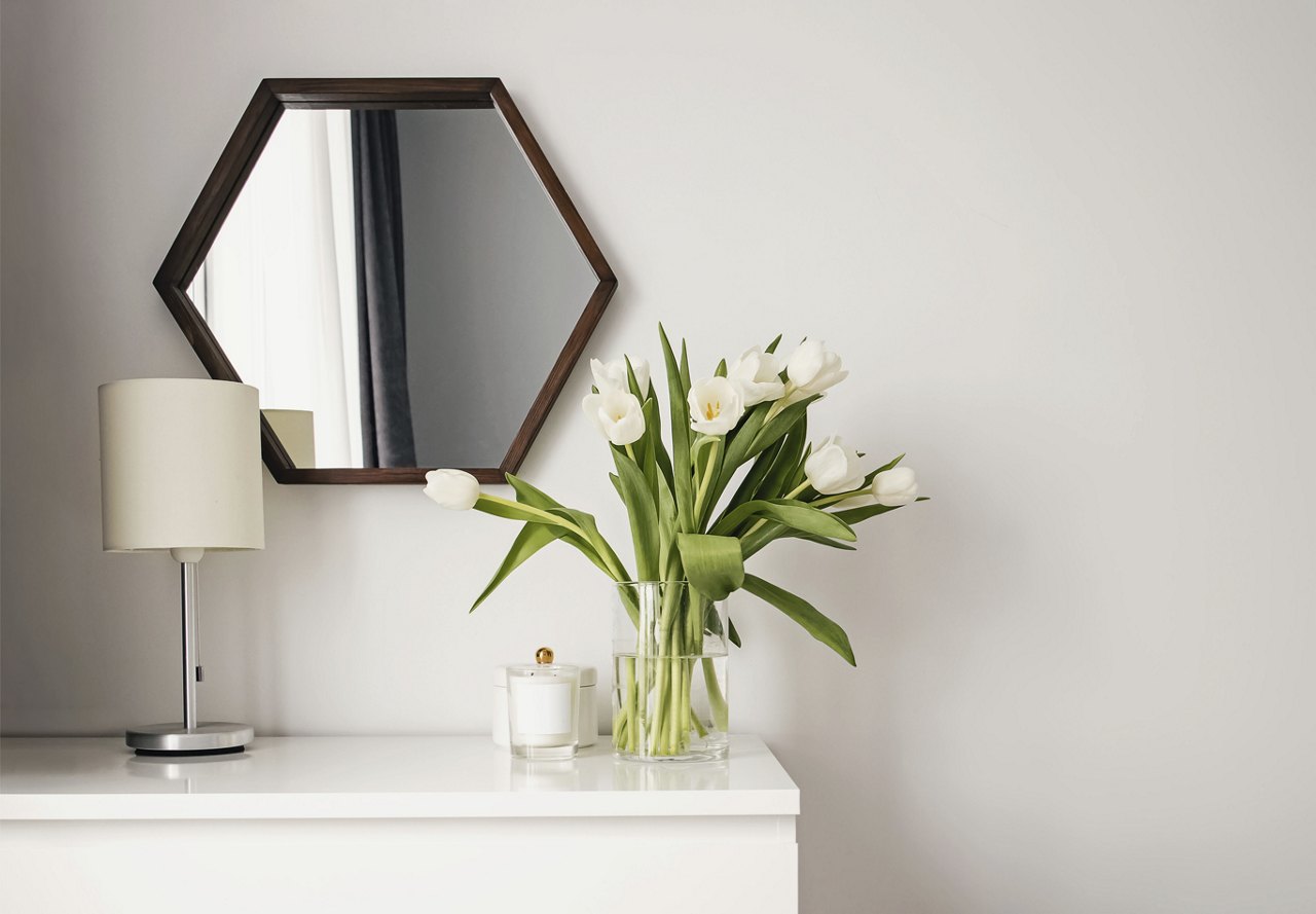 Table in a home with minimal decor and a mirror above