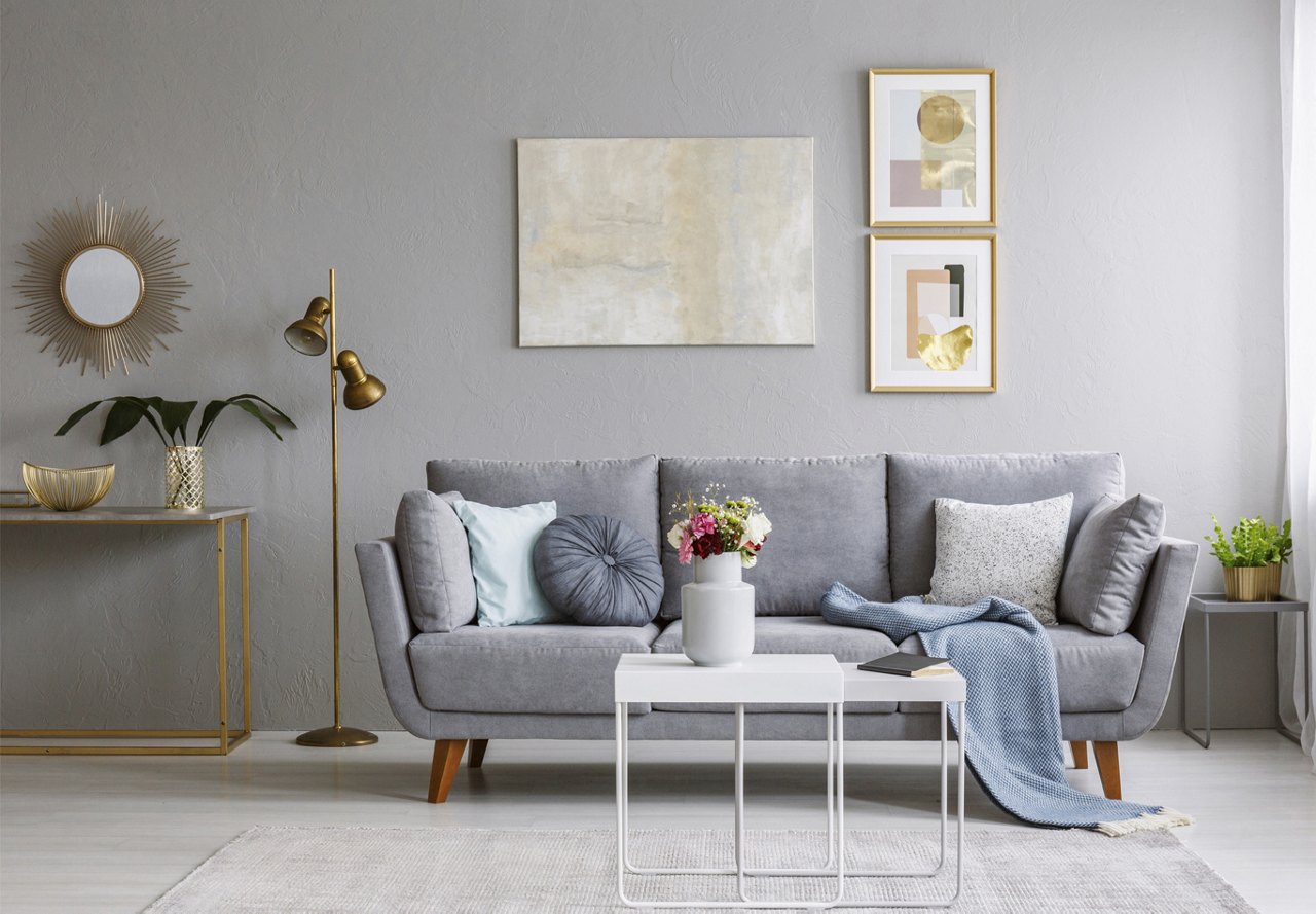 Apartment living room with wall decor and throw pillows on a grey couch