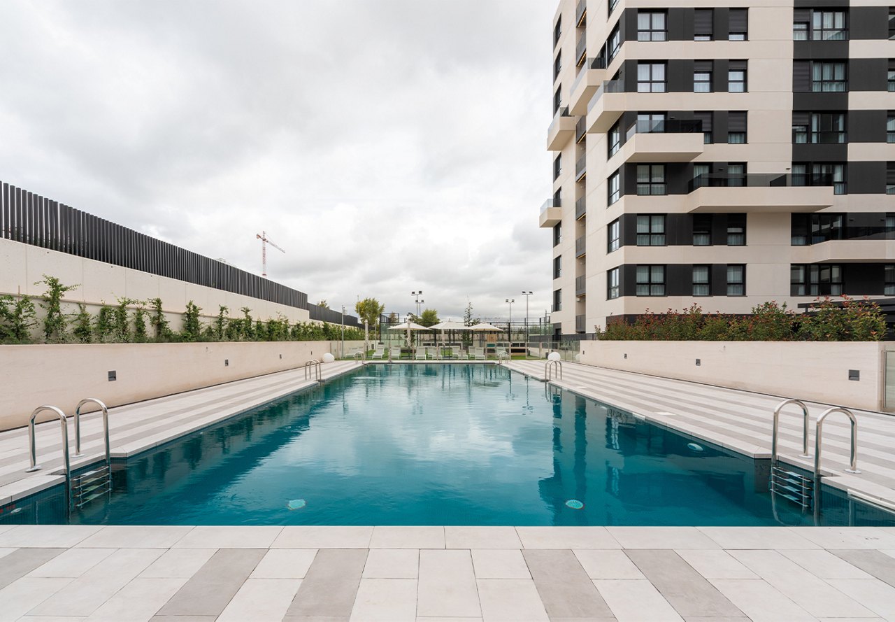 Apartment pool in outdoor space surrounded by greenery