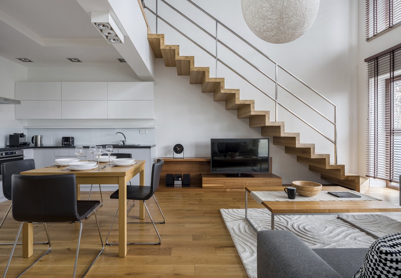 Open apartment space with lots of wood detail and white walls