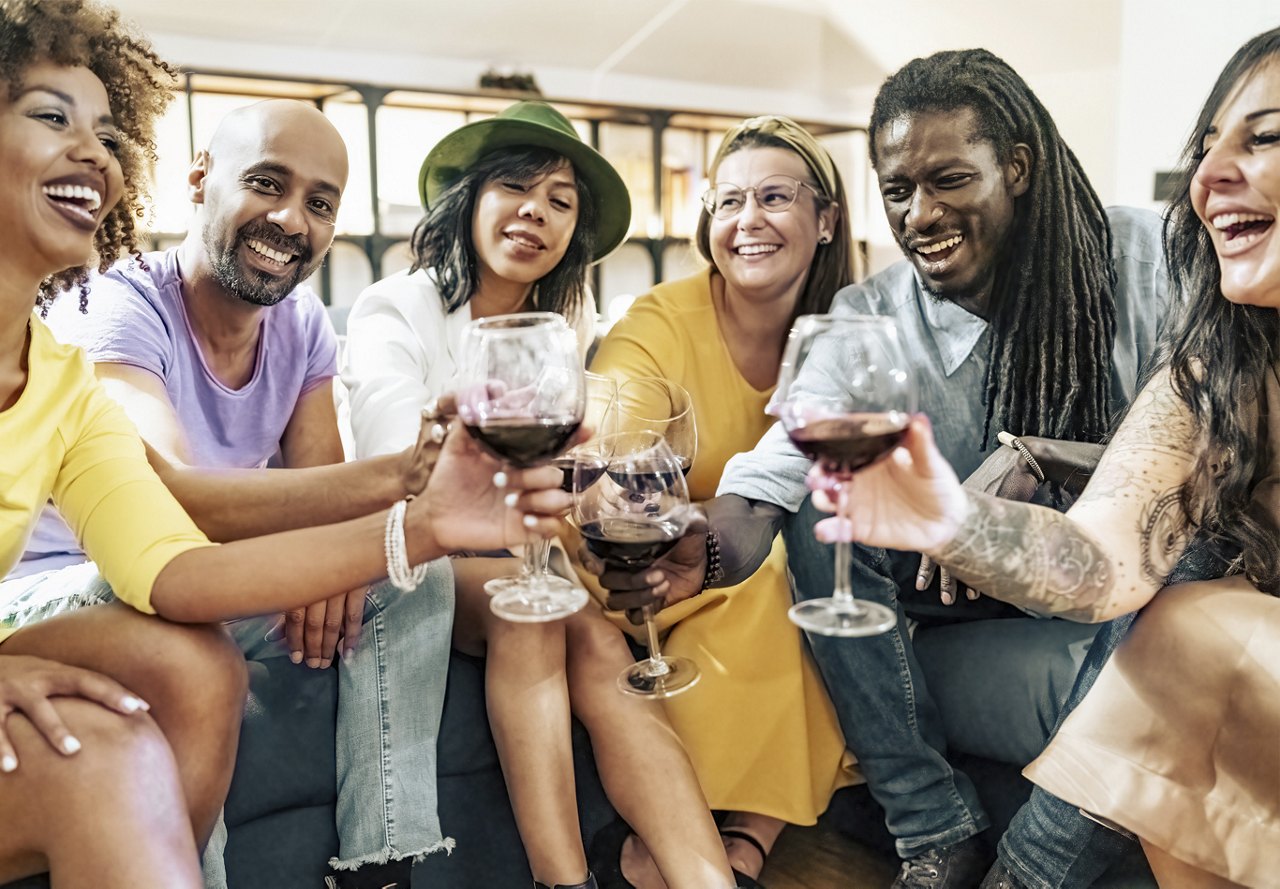 Diverse group of people doing a cheers together in an apartment setting